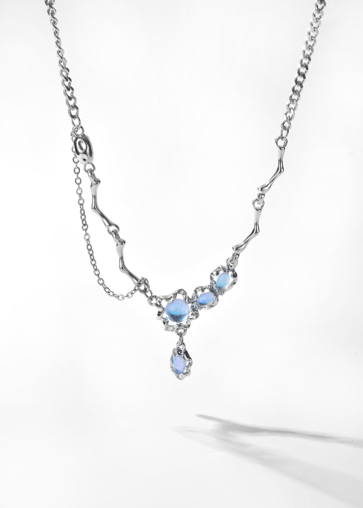 Lunar Drop Necklace with silver-tone chain and pale blue stones in a dangling pendant