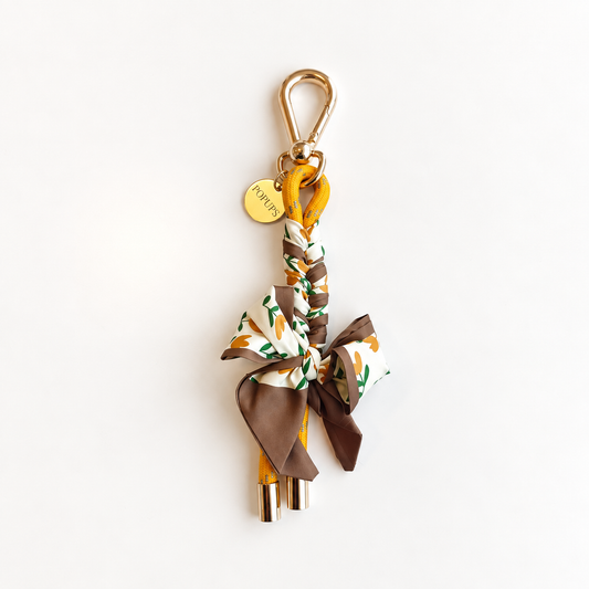 Patterned scarf keychain with gold keyring and clasp, brown and orange accents