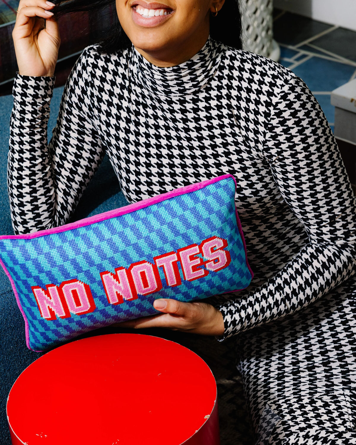 Needlepoint throw pillow with blue checker pattern and raised “NO NOTES” embroidery