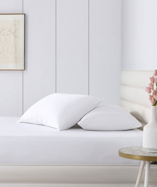 White bamboo viscose fitted sheet on bed with matching pillows and bedding.