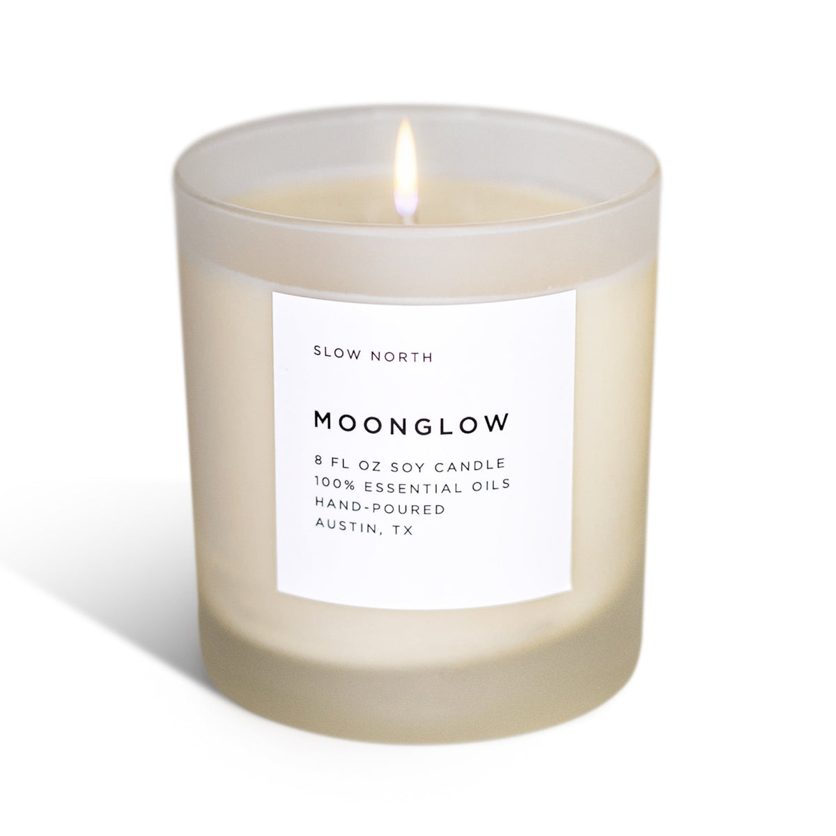 Lit Moonglow soy candle in a frosted glass jar with a white label.