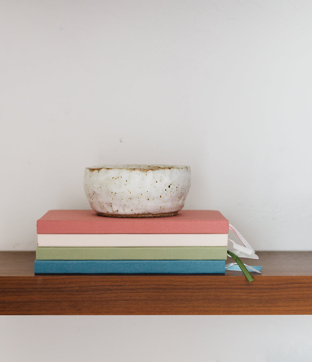 Colored notebooks stacked together with ribbon ties