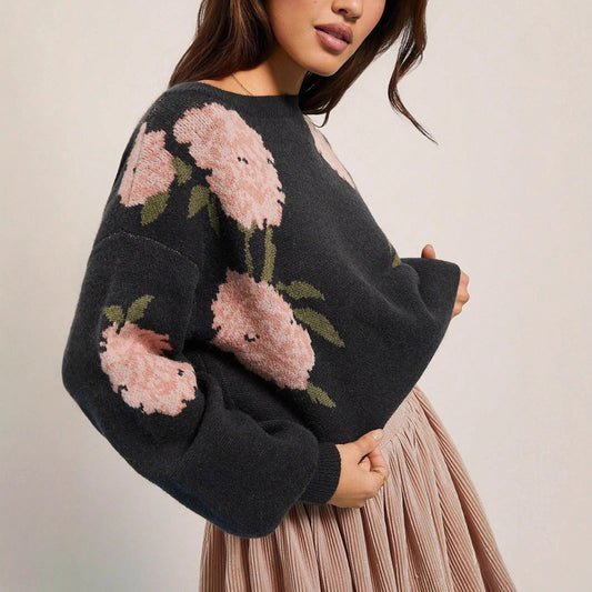 Black round-neck loose-knit sweater with large pink and green floral pattern