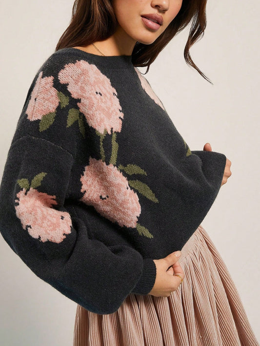 Black round-neck loose-knit sweater, front floral motif on dark knit