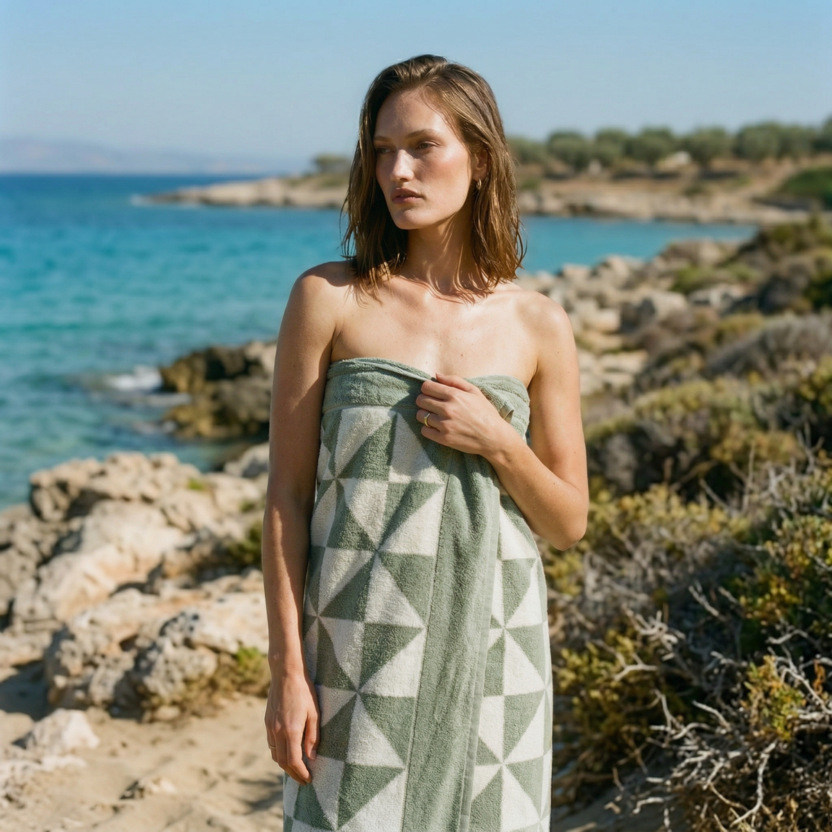 Cotton beach towel with green geometric pattern, wrapped around the body