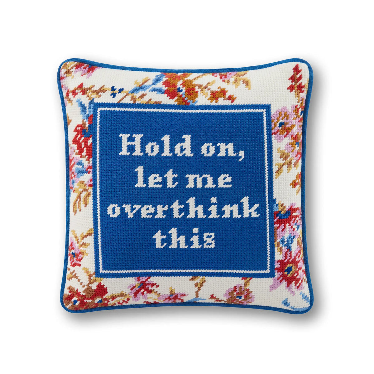 Needlepoint throw pillow with blue center panel and embroidered quote, surrounded by floral border