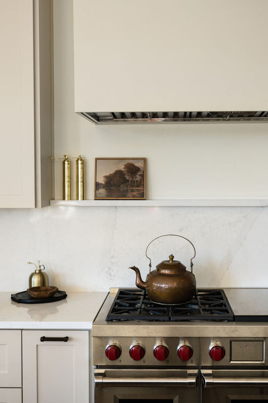 Brass and copper kettle on stovetop, with domed lid and curved handle
