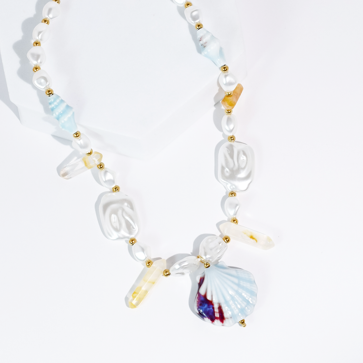 Beaded ocean necklace with gold spacers and blue fan shell plus clear shell charms