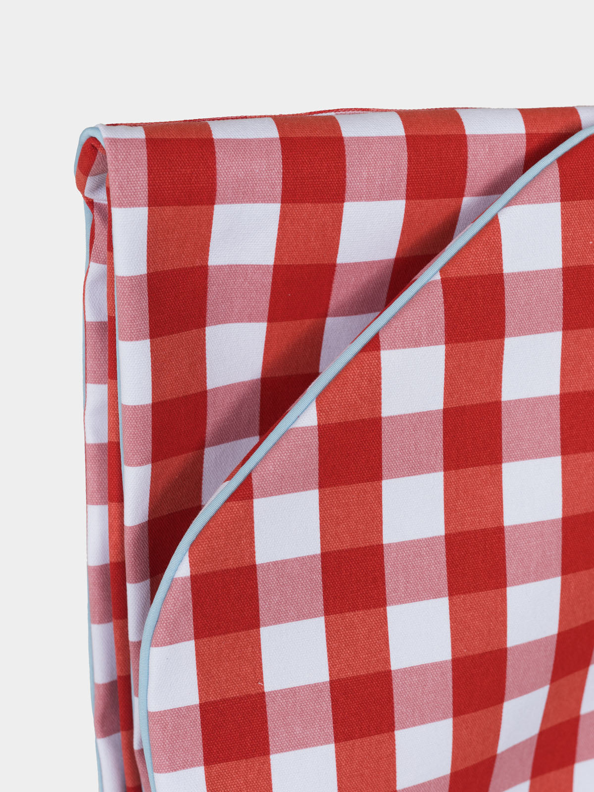 Close-up of red and white gingham fabric and pale blue edge piping