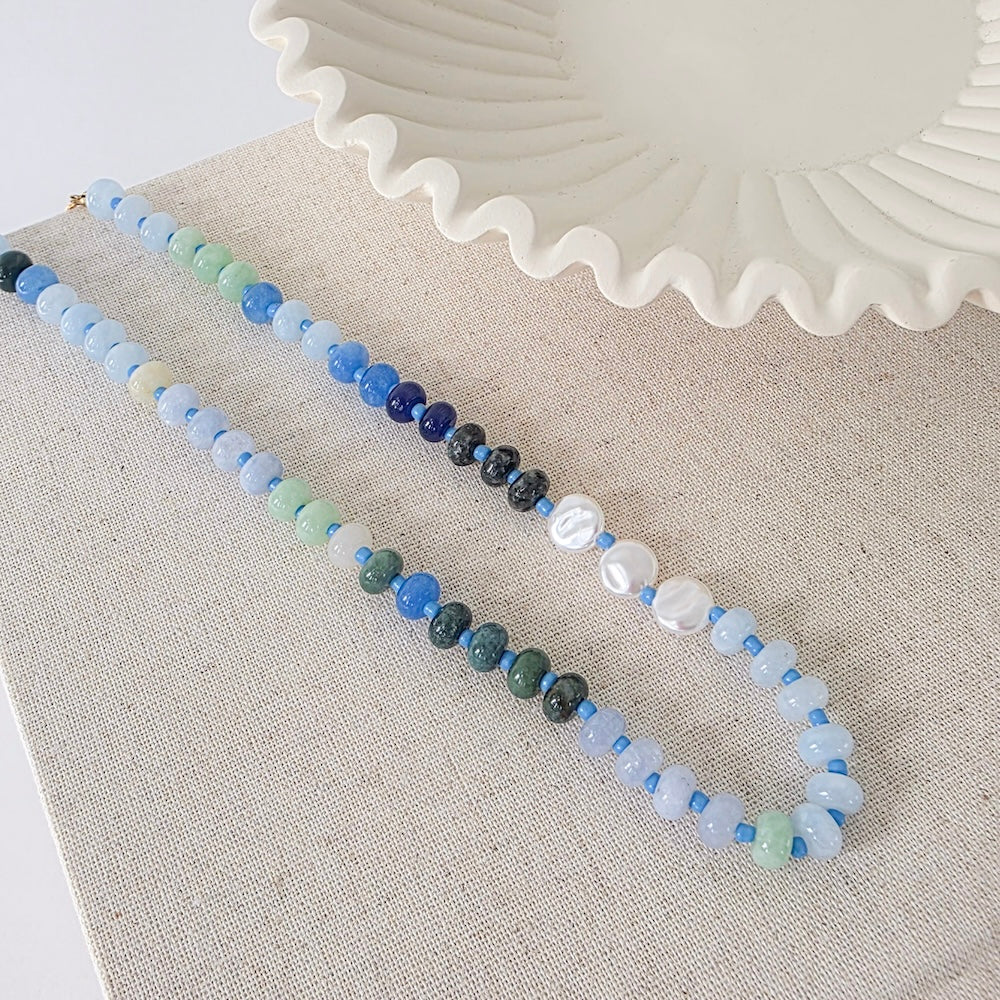 Waterproof ombre beaded necklace pair with blue and white round beads and dark accents