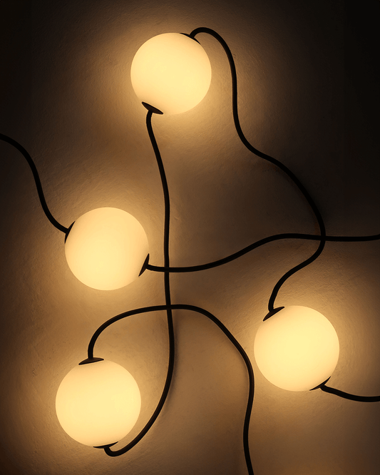 Plug-in orb string lights with glowing spheres on black wire