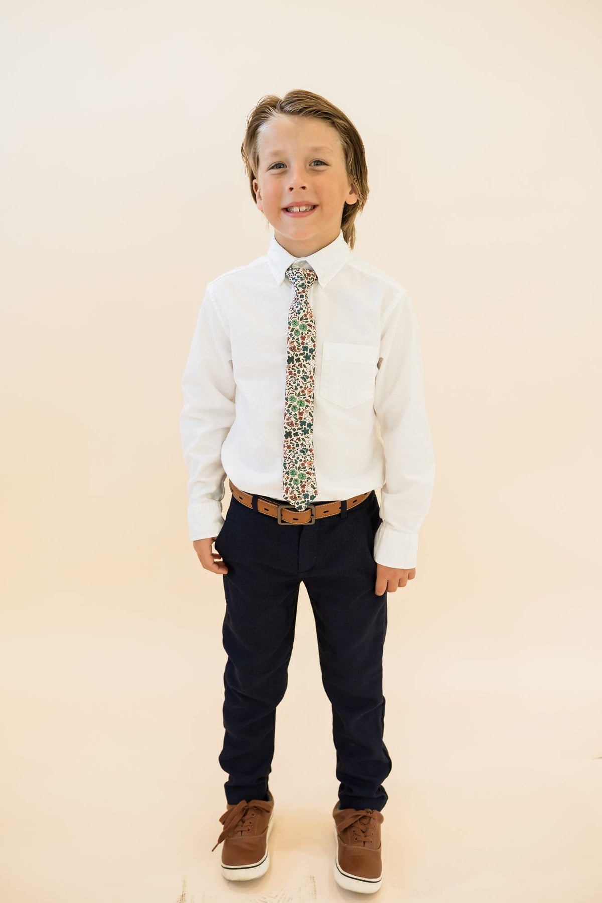 Boys floral tie worn with white shirt and dark pants
