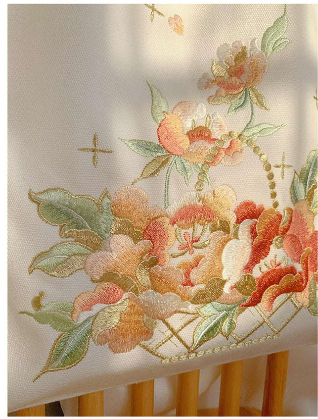 Close-up of white floral basket embroidery on the front of a tote bag.