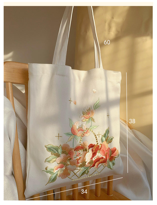 White embroidered tote bag with flower basket design and cross details.