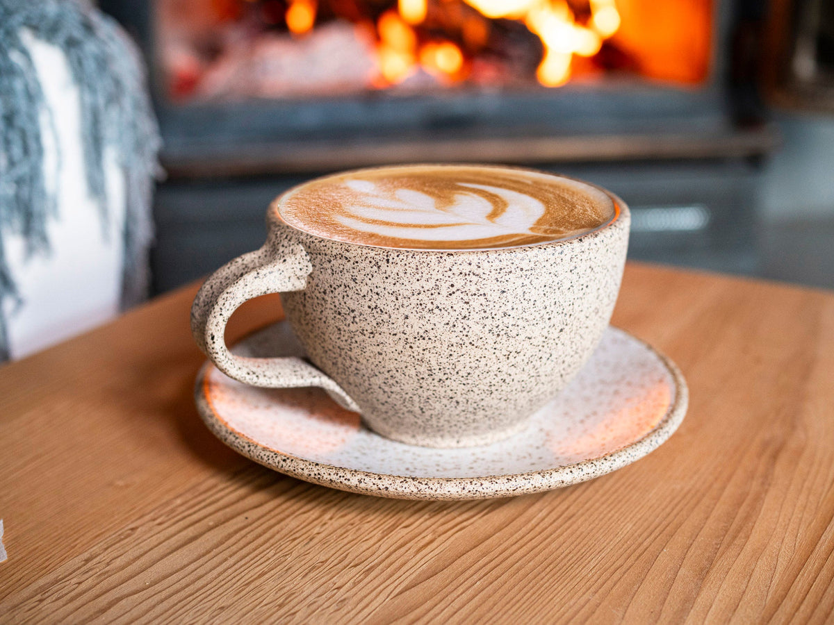 Speckled stoneware cappuccino cup with handle and matching saucer, latte size