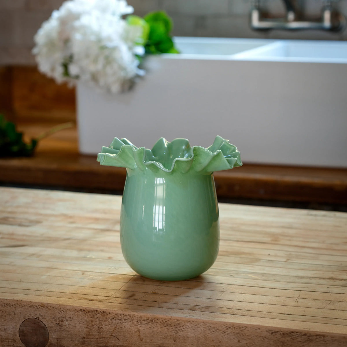 Green ceramic blossom vase with ruffled rim and glossy finish