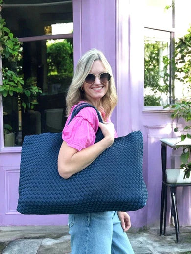 Woven carryall tote, navy blue, held by woman with matching tile pouch at side