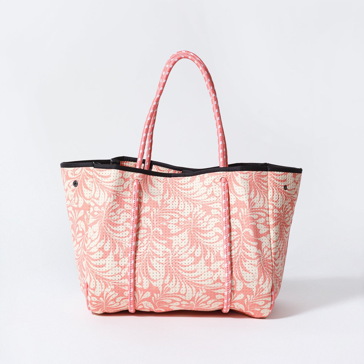 Pink patterned tote bag with black handles and top trim, rectangular shape