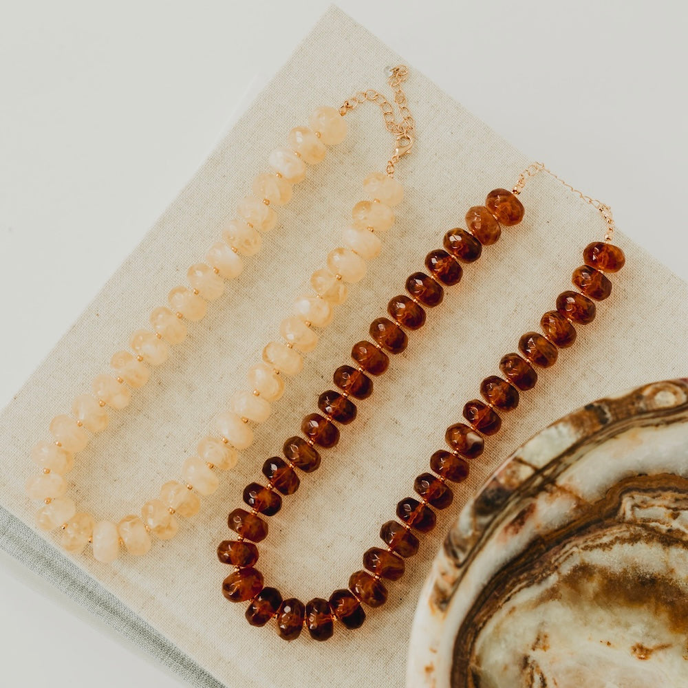 Resin beaded necklace on display with ivory and dark amber bead strands
