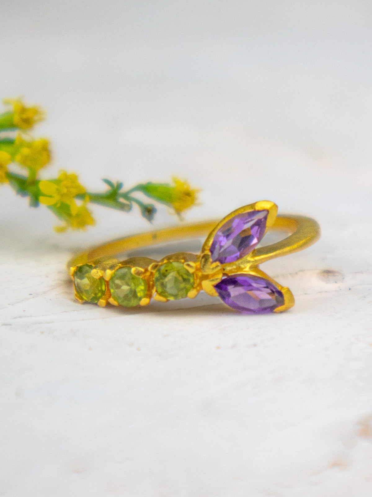 Vine ring with green peridot stones and two purple amethyst marquise accents