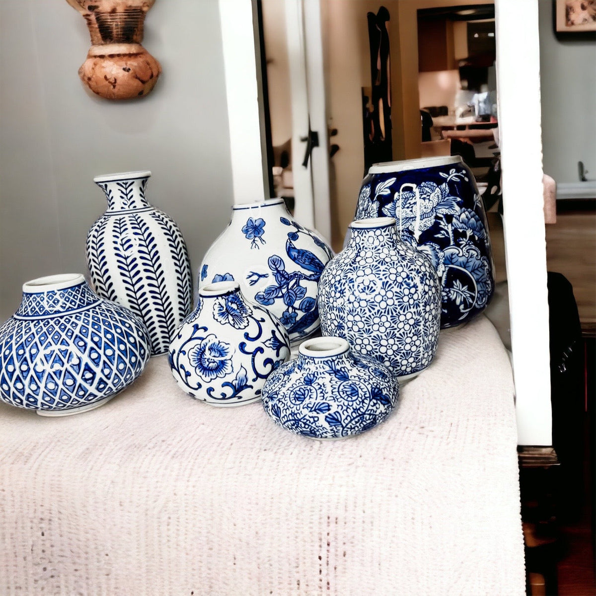 Blue-and-white ceramic vases arranged along a doorway sill