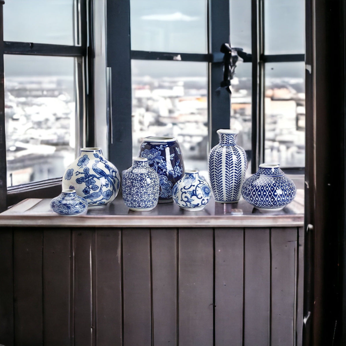 Small blue-and-white ceramic vases on a window ledge in a row