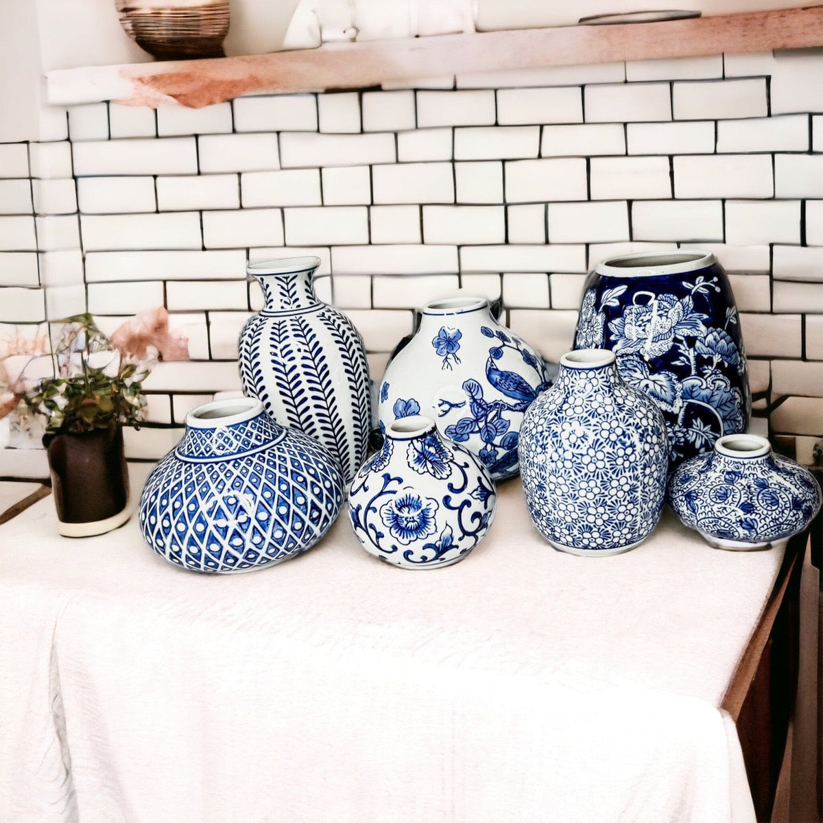 Blue-and-white ceramic vases on a dresser against a white tile wall