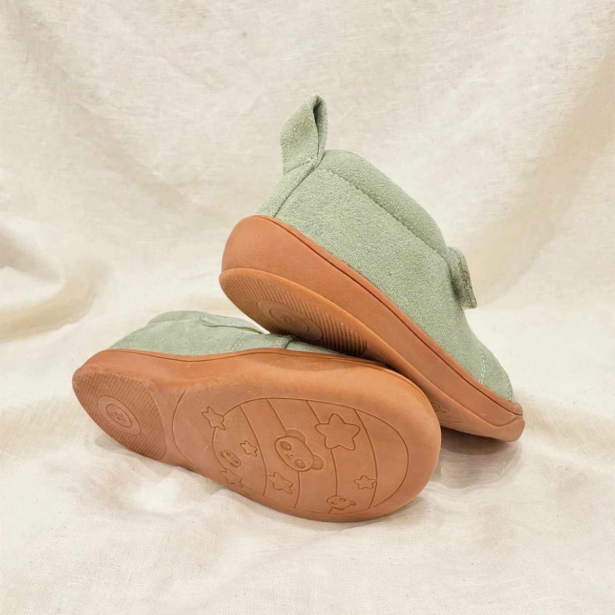 Kids’ light green barefoot sneakers shown from side with textured brown rubber outsole