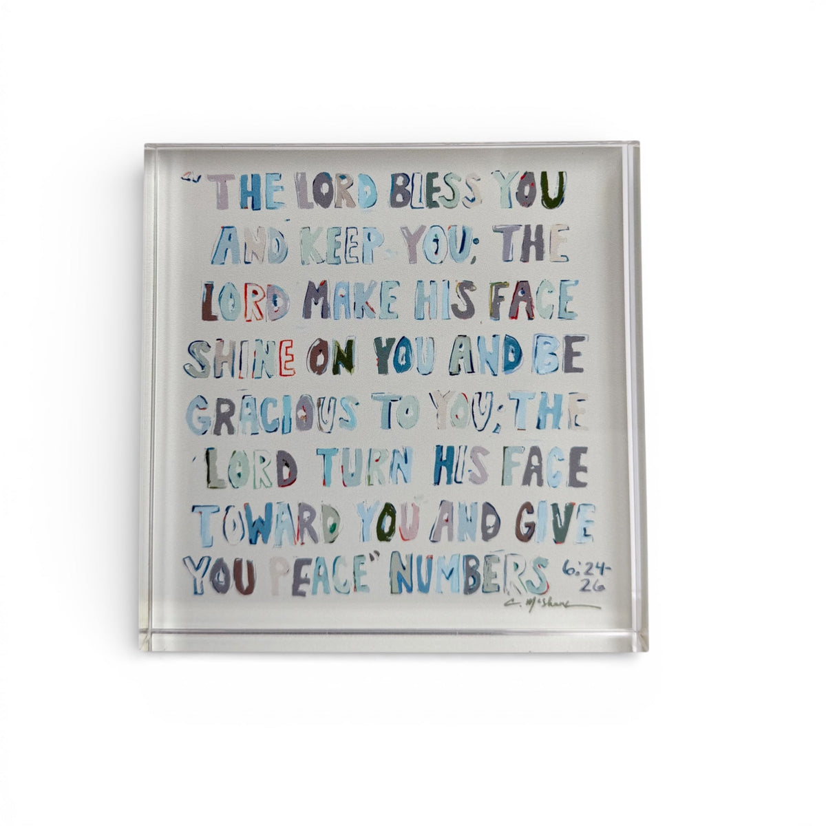 Clear acrylic tabletop art with blue scripture text in clear frame.