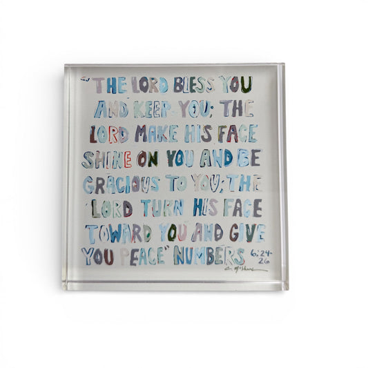 Clear acrylic tabletop art with blue scripture text in clear frame.