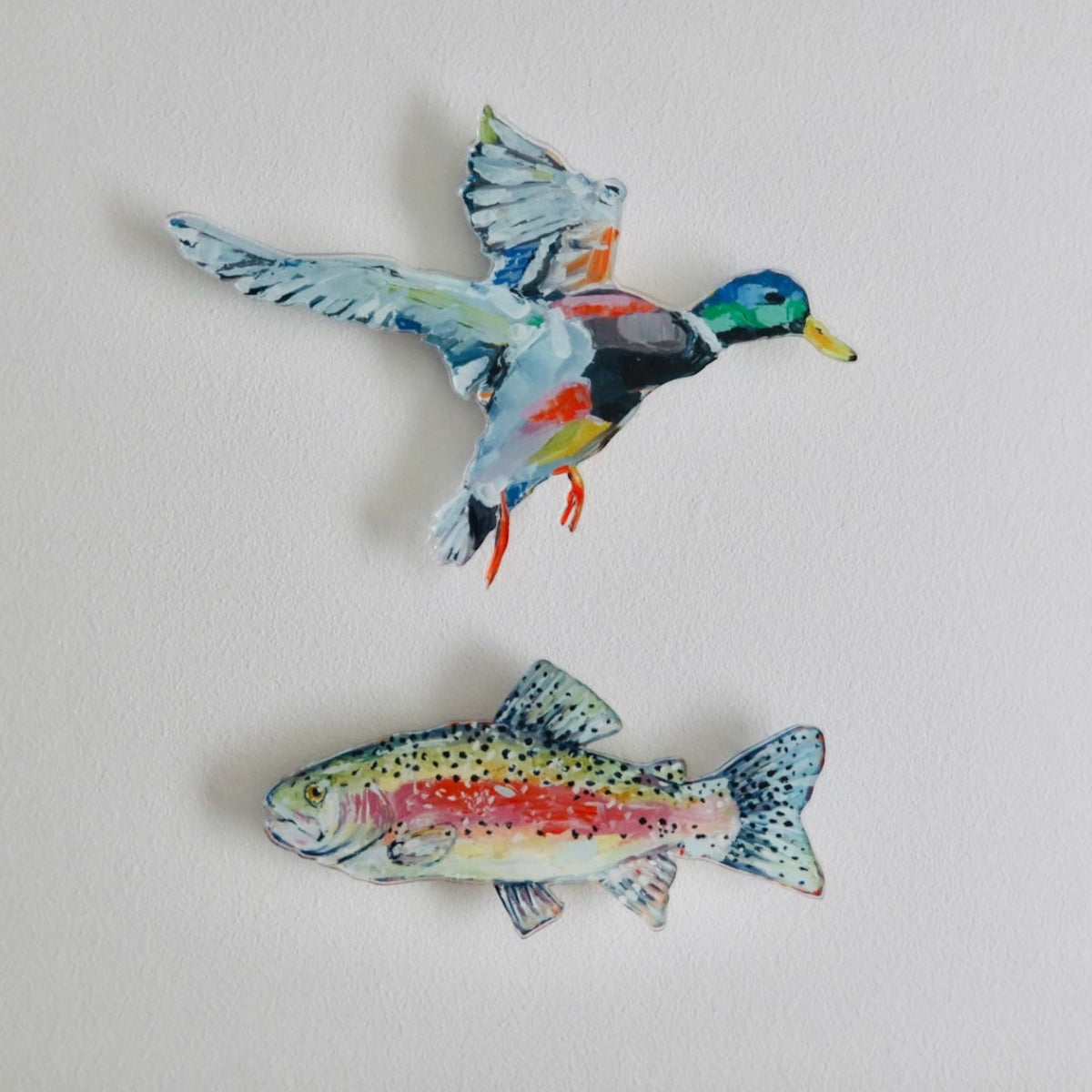 Colorful acrylic wall art of a trout fish and a multicolor bird in flight