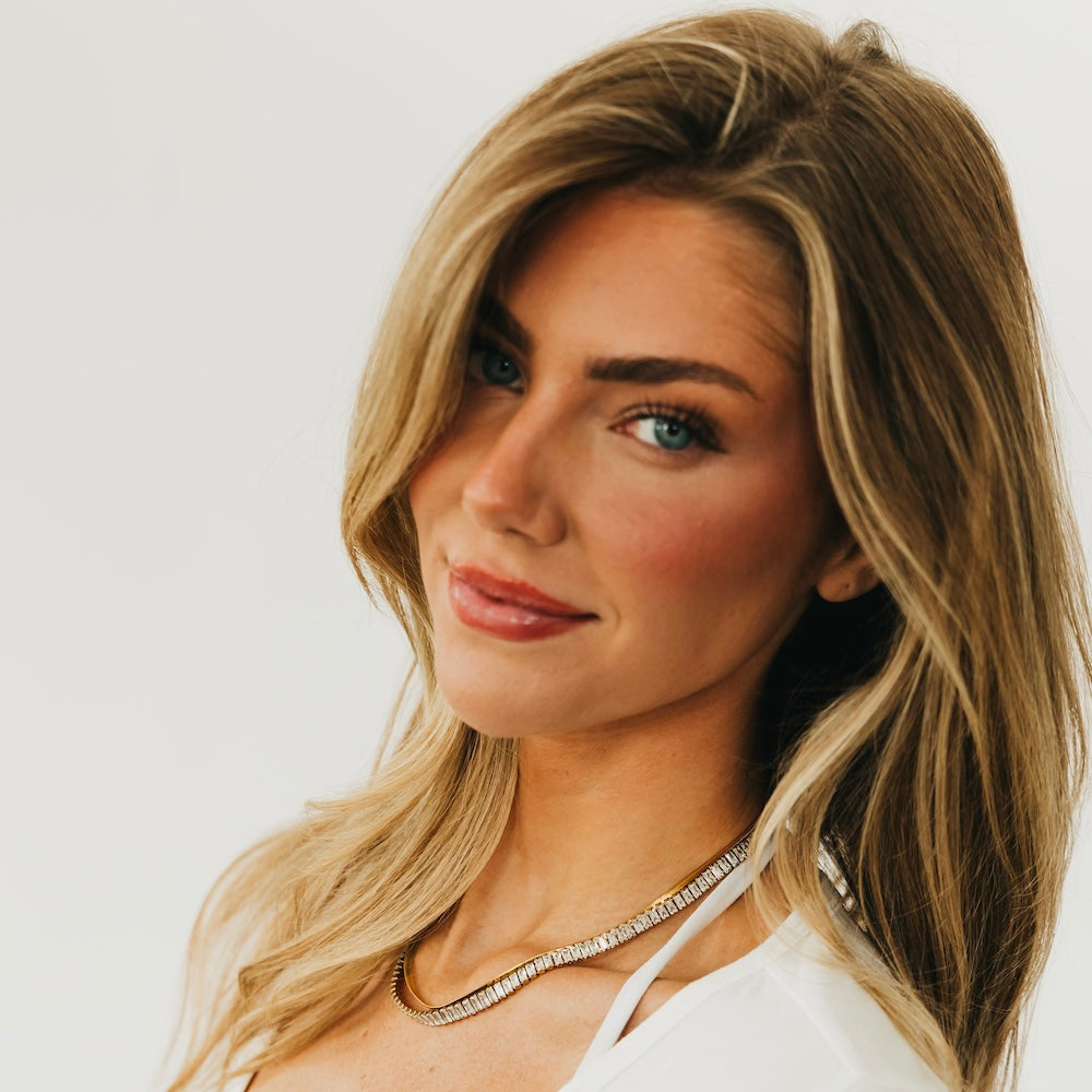 Gold layered necklace on model, two sparkling rows at neckline
