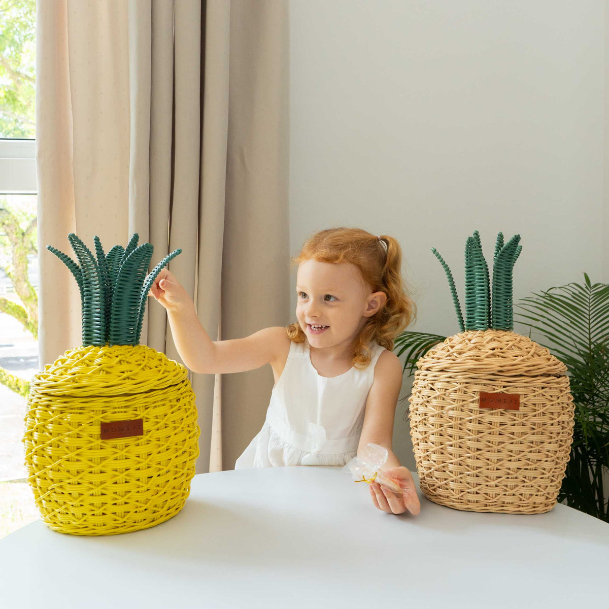 Natural rattan pineapple basket with green woven leaves and a fitted lid