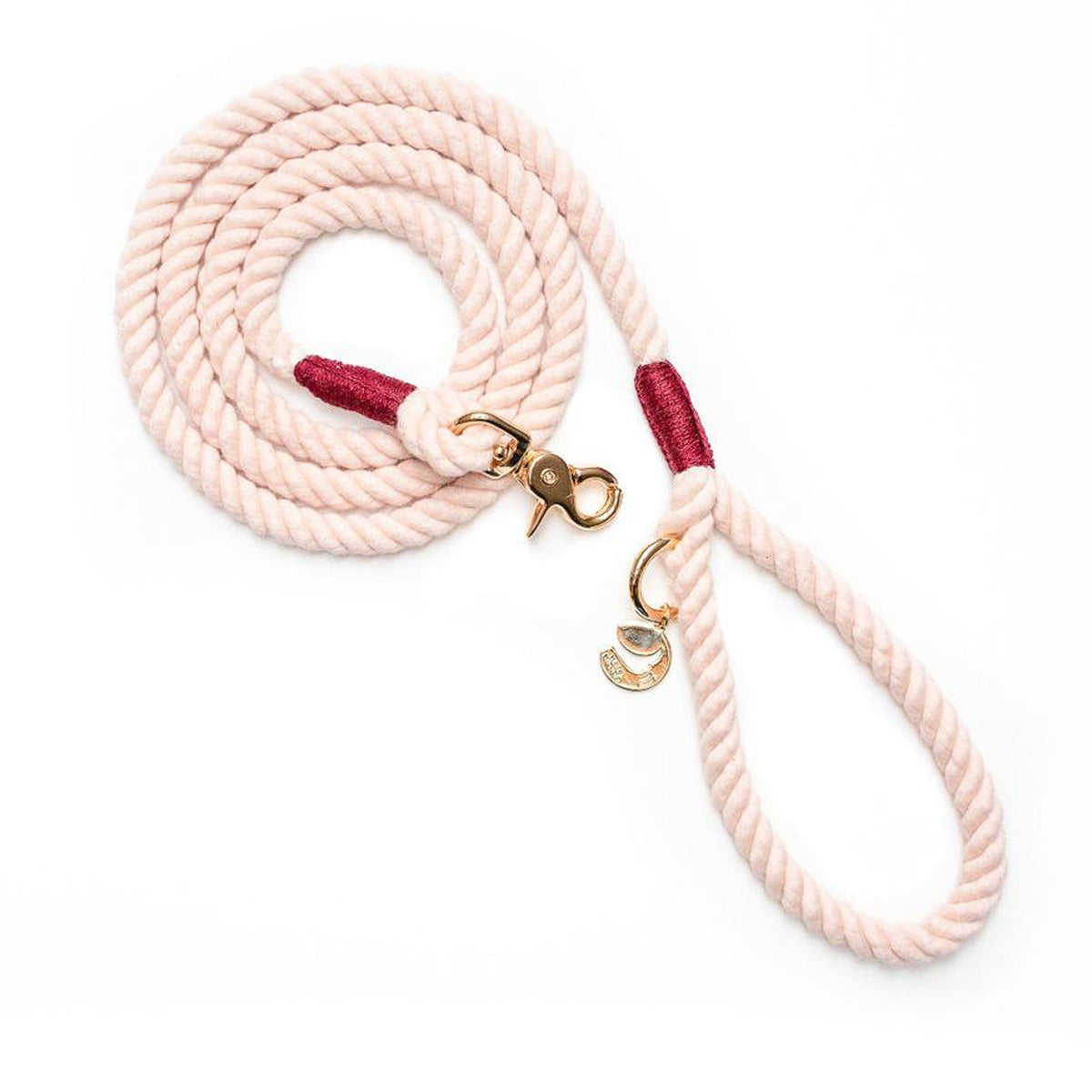 Rope dog leash with brass clasp, burgundy end stitching, and light pink braided handle