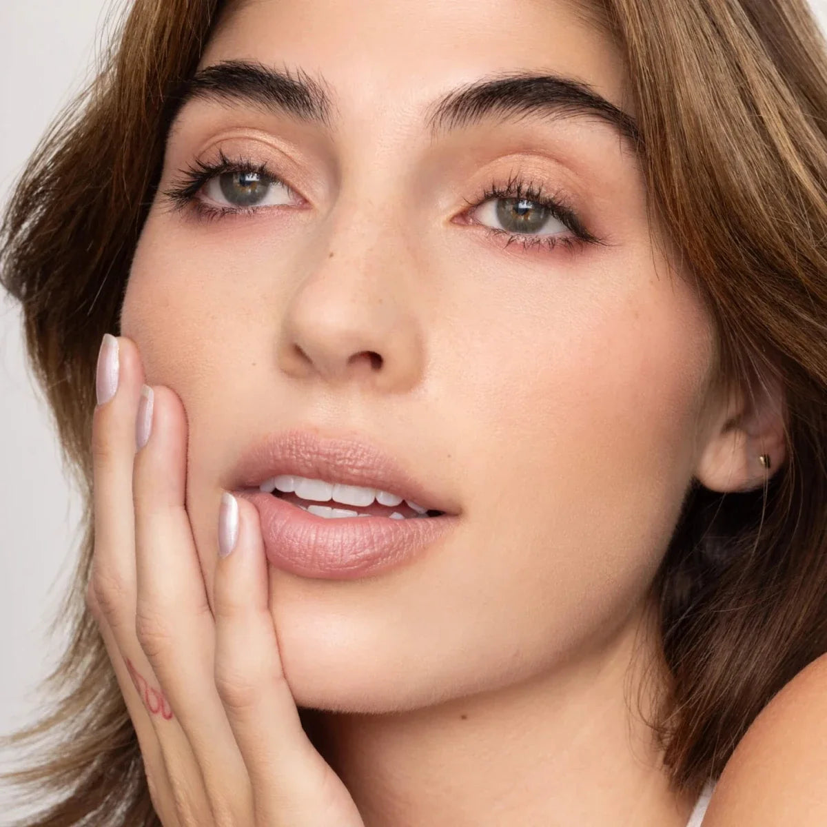 Lip tint shade on lips, rosy nude finish with subtle shimmer
