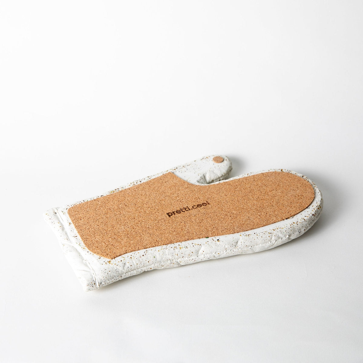 White terrazzo quilted oven mitt with brown heat-resistant backing and stitched label.