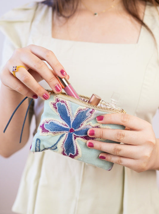 Light mint zip pouch with colorful floral embroidery and gold zipper pull
