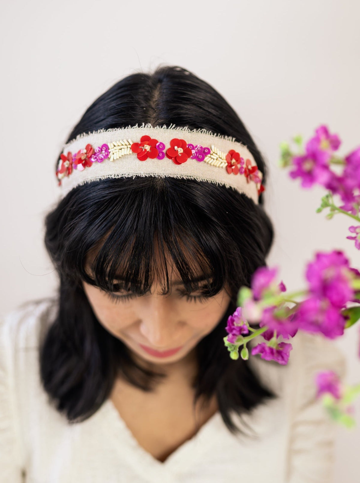 Beaded floral headband with red and purple sequined beads on cream band