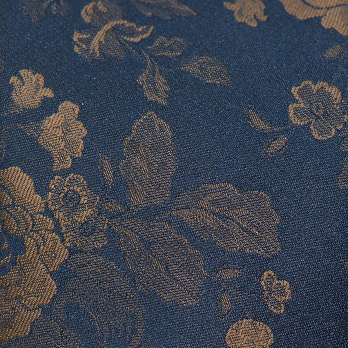 Boys tie fabric close-up: dark navy weave with tan-gold floral and scroll pattern