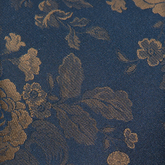 Close-up of dark blue fabric tie with gold floral and lattice pattern