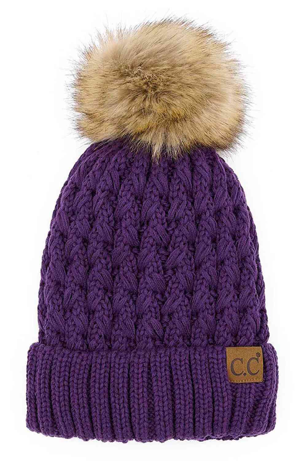Purple knitted beanie with fluffy pom-pom and C.C patch on ribbed cuff.