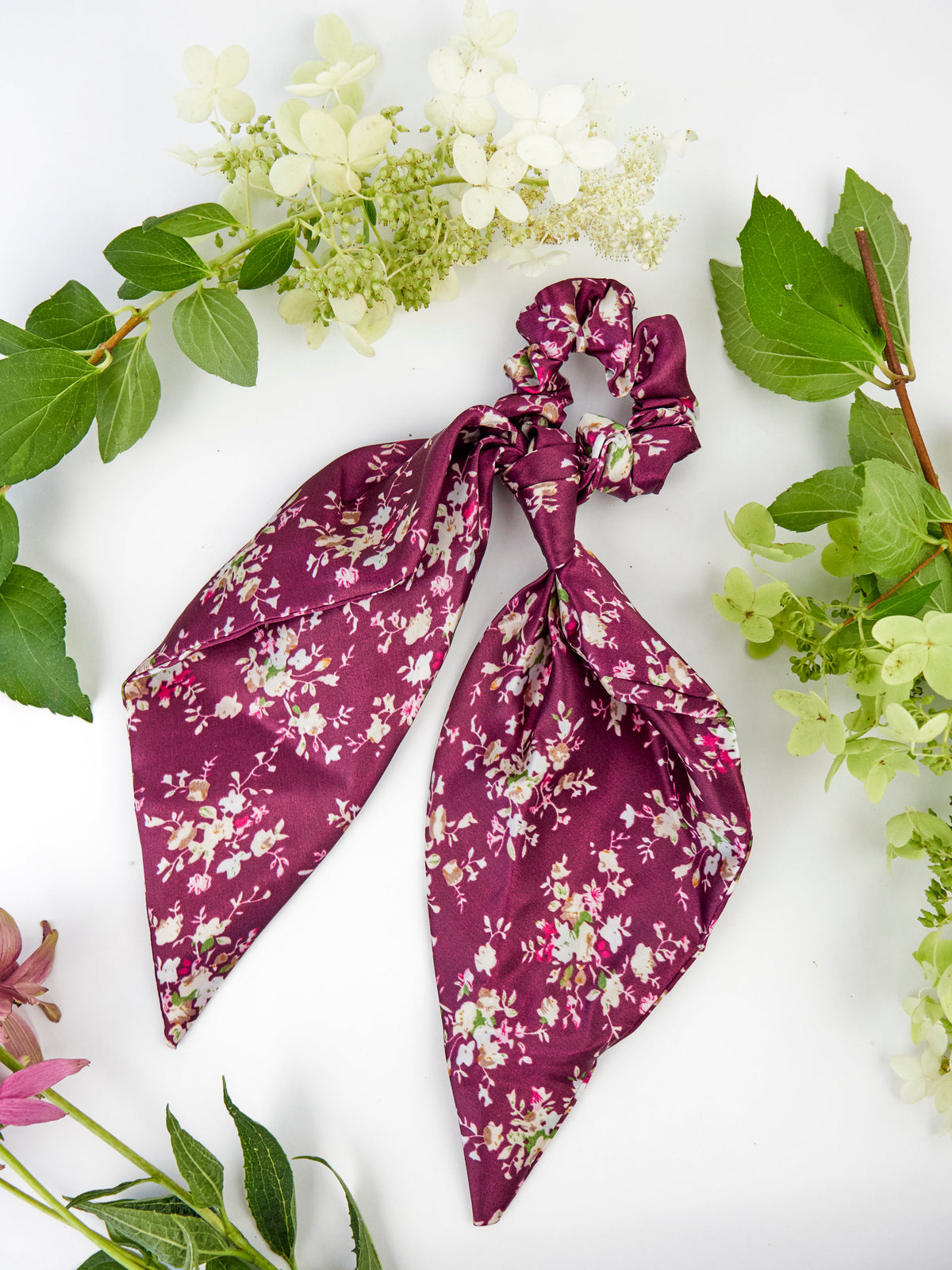 Purple satin floral scarf scrunchie with long tails tied in a bow