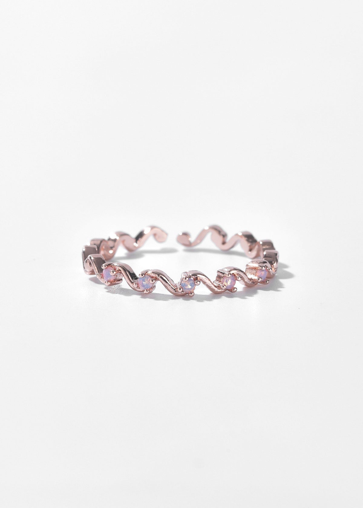Rose gold wavy ring with small clear stones along the band.