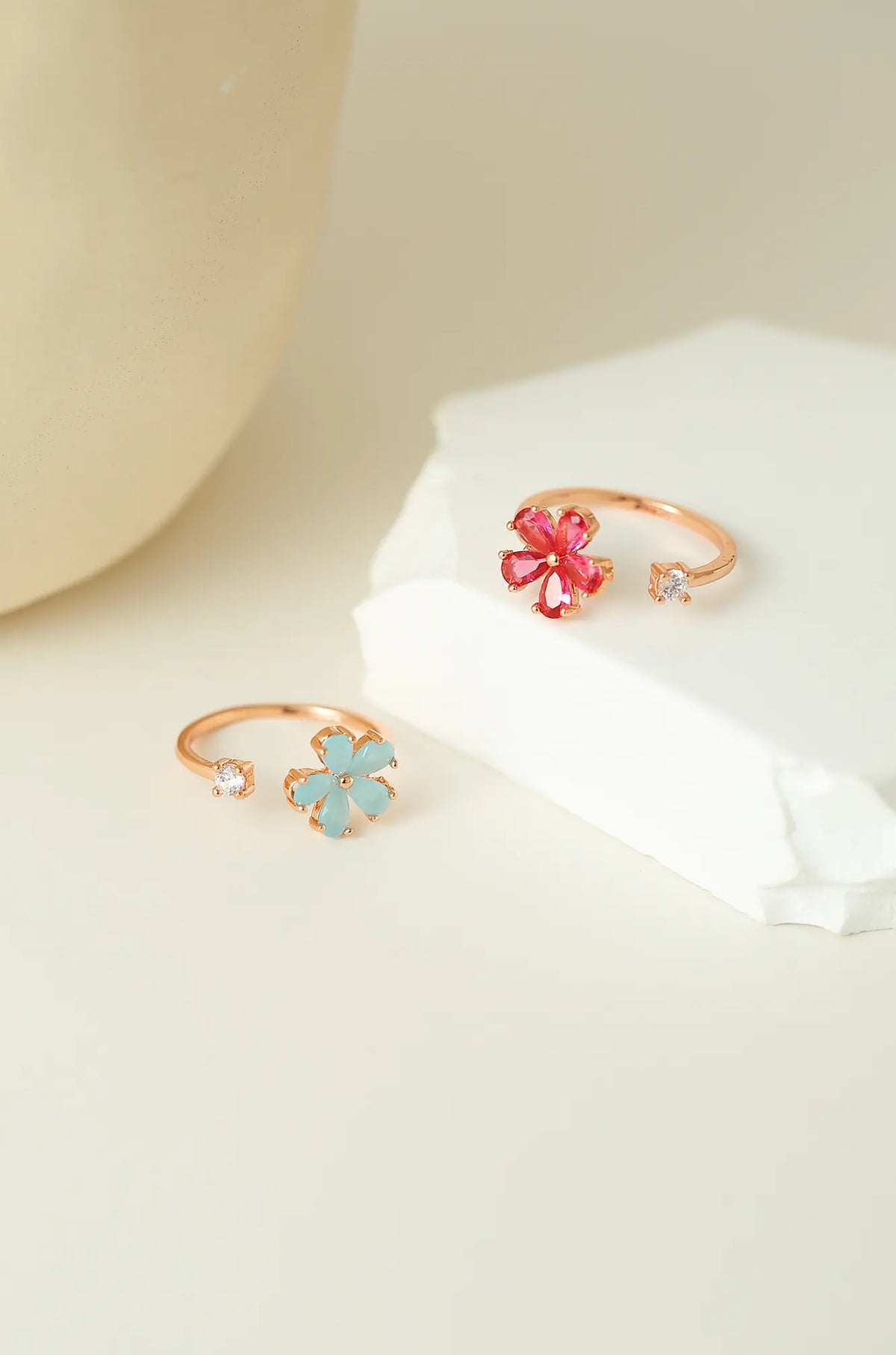 Gold-tone open rings with red and light blue flowers and clear accent stones