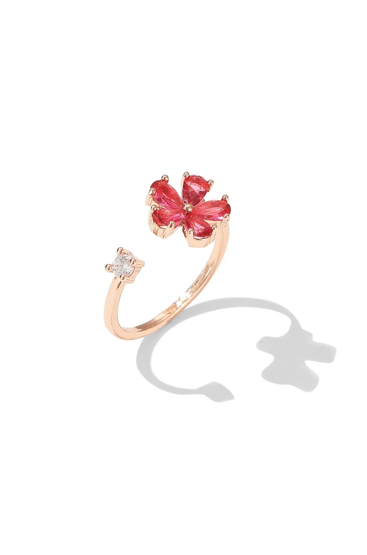 Open gold-tone ring with a red flower and a clear accent stone