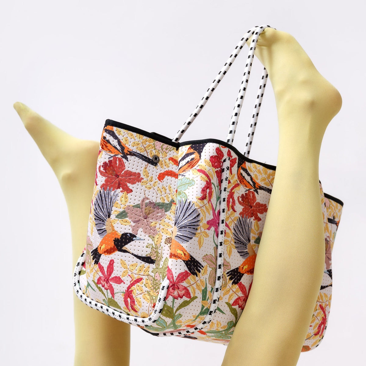 Floral patterned tote bag with striped handles and structured shape