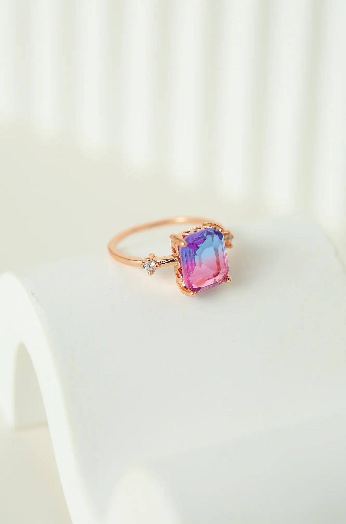 Reverse angle of the rose gold ring, showing its rectangular pink and violet sapphire and side stones
