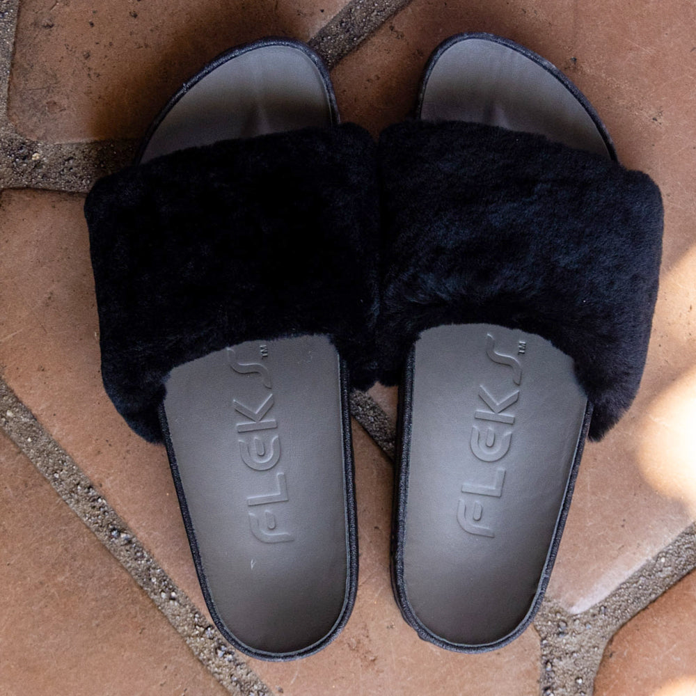 Black slide sandals with faux-fur straps and molded logo footbeds