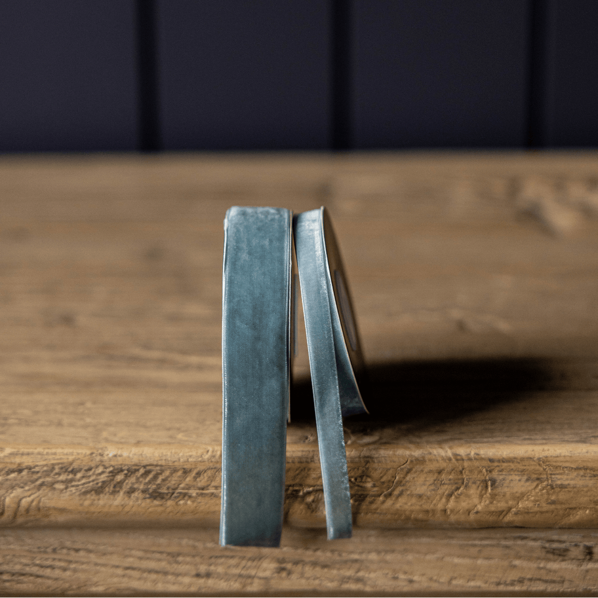 Teal blue velvet ribbon roll with narrow ribbon ends hanging
