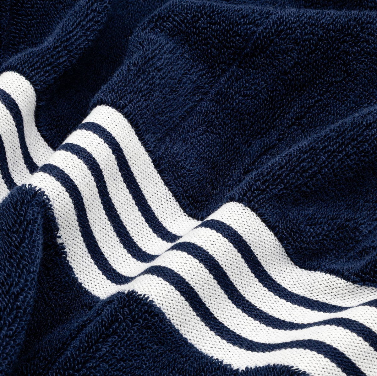 Nautilus navy cotton towel close-up with bold white wavy stripe trim